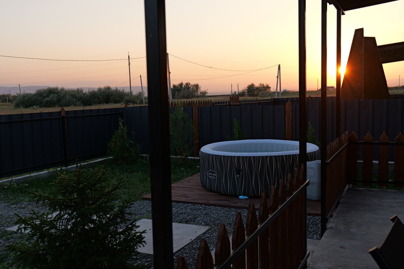 Outdoor Jacuzzi in a private Sky Cabins Ranch yard at sunset with distant hills near Tbilisi